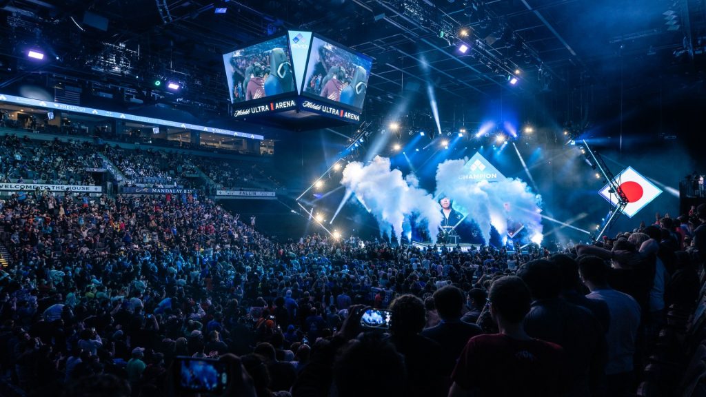 Screenshot of EVO fighting tournament with smoke firing in front of crowd