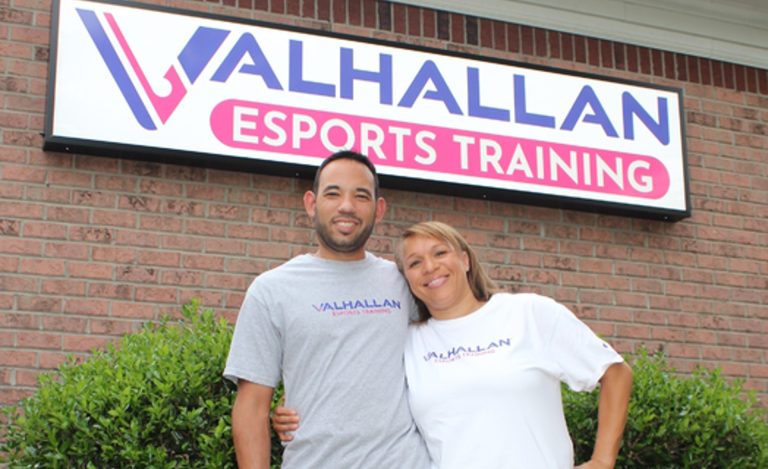 Screenshot of Alexi and Cinamon Claudio standing in front of Valhallan esports sign
