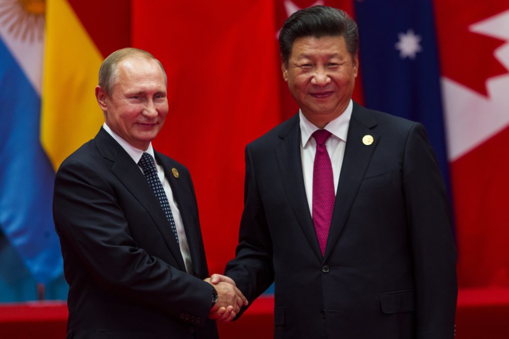 Vladimir Putin and Xi Jingping shake hands