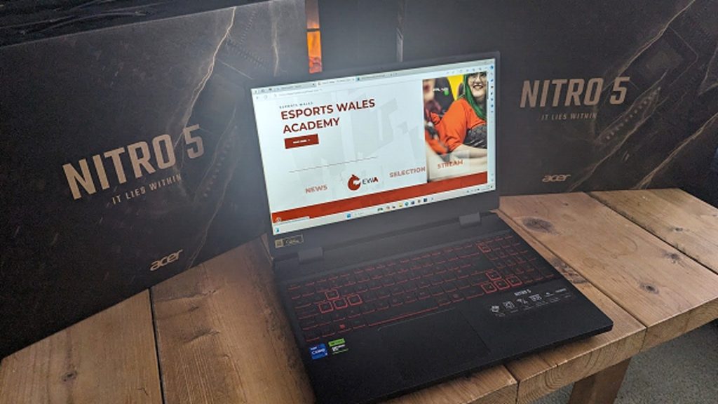 Image of Acer laptop displaying Esports Wales logo with laptop boxes in background